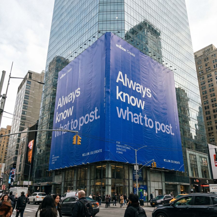 Willow Create-gebouwwrap op een glazen wolkenkrabber met de tekst 'Weet altijd wat je moet posten.'